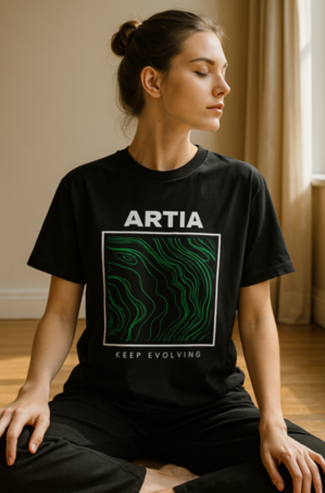 Czarny tshirt oversize z zielonym artystycznym wzorem wkoponowanym w biały kwadrat z białym napisem, nad nim. uszyty z dobrej bawełny, prezentowany na modelce. Nadruk na przodzie