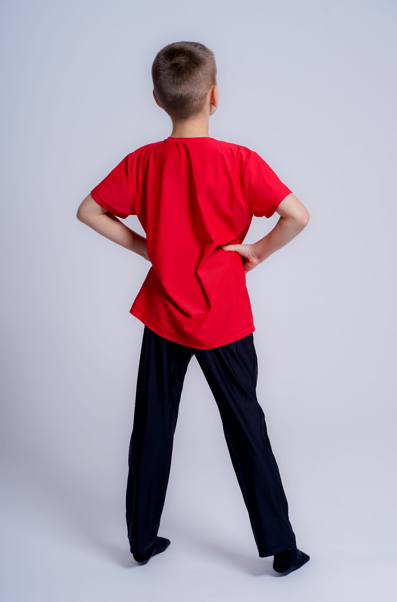 czarne Spodnie męskie z napisem artia na udzie. Prezentowane na modelu. widok całej postaci z tyłu.