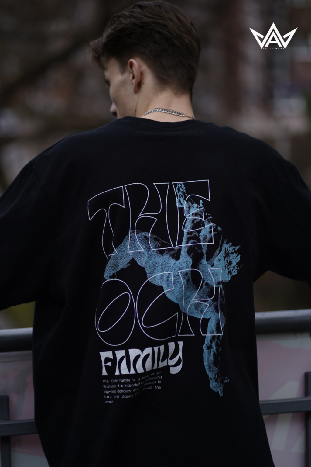Czarny tshirt oversize z zieloną postacią artystycznie narysowaną i białym napisem, uszyty z dobrej bawełny, prezentowany na modelu. Nadruk na plecach