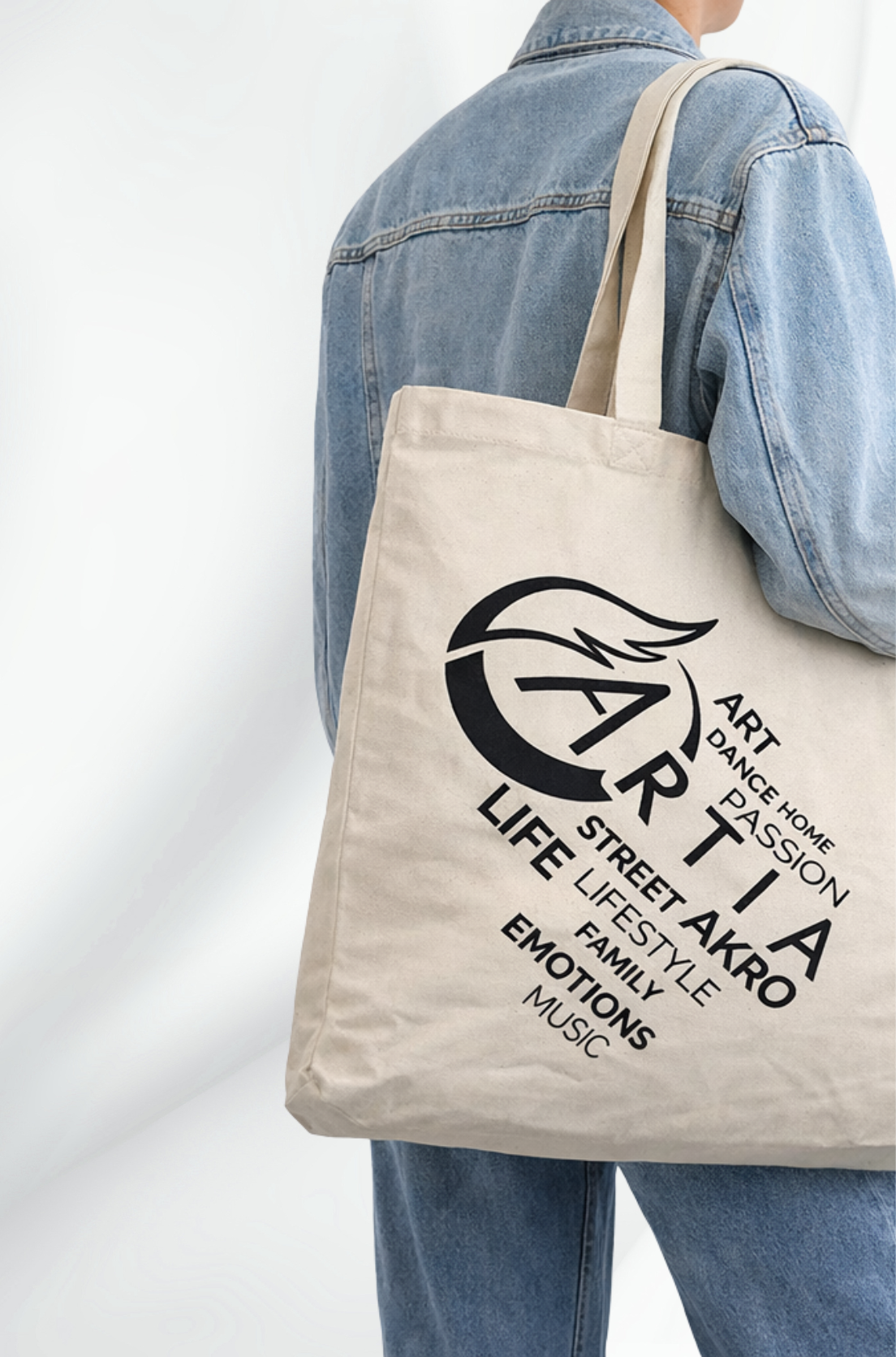 kremowa torba materiałowa z napisem czarna grafika artia złożoną z napisów. widok torby na ramieniu modela