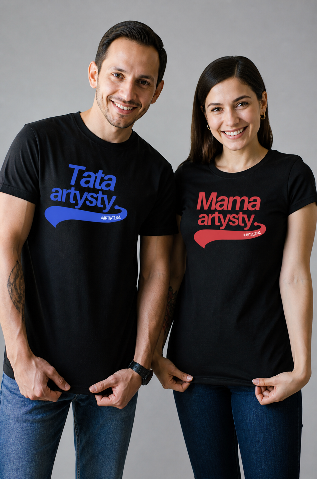 czarna koszulka z niebieskim napisem tata artysty prezentowane na modelu oraz czerwonym napisem mama artysty prezentowane na modelce. widok z przodu. osoby stoją obok siebie.